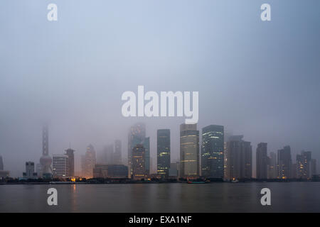 Chine, Shanghai, des gratte-ciel dans l'horizon de Pudong District perdu dans les nuages bas le long de la rivière Huangpu sur matin d'hiver Banque D'Images