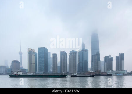 Chine, Shanghai, des gratte-ciel dans l'horizon de Pudong District perdu dans les nuages bas le long de la rivière Huangpu sur matin d'hiver Banque D'Images