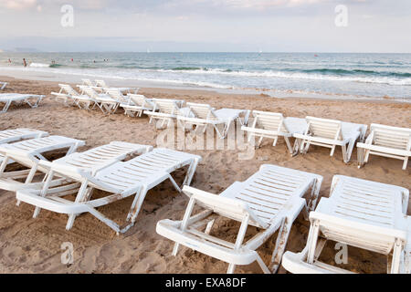 Chaises longues sur la plage de la Méditerranée, Alicante, Espagne Banque D'Images