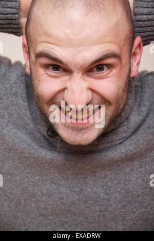 Fashion portrait du beau jeune homme dans un chandail gris isolé sur fond blanc Banque D'Images