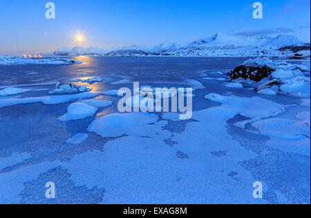 Réflexions de pleine lune dans la mer gelée, Lyngedal, îles Lofoten, Norvège, de l'Arctique, Scandinavie, Europe Banque D'Images