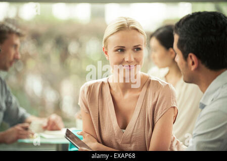 Woman smiling at collègue masculin au cours de réunion occasionnels Banque D'Images