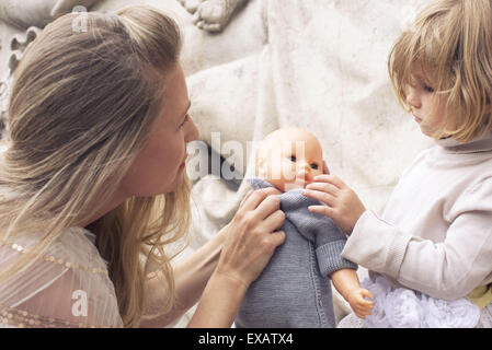 Mère et fille jouant avec baby doll ensemble Banque D'Images