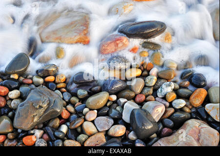 L'eau colorée cailloux lissés en surf à plage de galets Banque D'Images