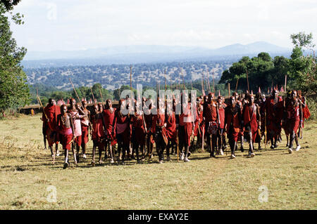 Lolgorian, au Kenya. Manyatta Masaï Siria ; un groupe de jeunes de couleur ocre rouge Moran, cheveux courts, Shell et décorations. Banque D'Images