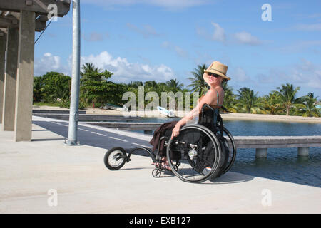 Femme utilisant un fauteuil roulant à côté à Belize Banque D'Images