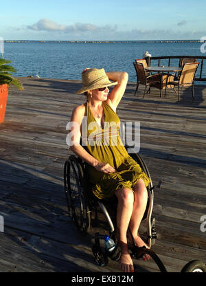 Femme à l'aide d'un fauteuil roulant à la station à Belize Banque D'Images