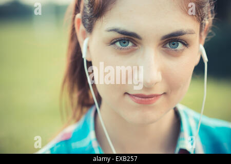 Belle jeune hipster woman listening music dans la ville Banque D'Images