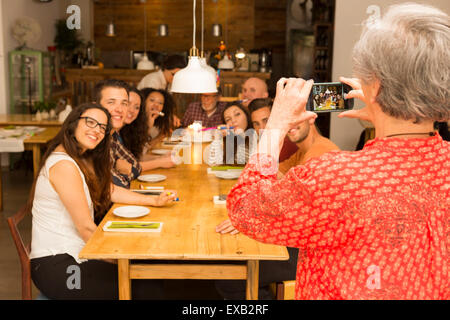 Granny en tenant une photo de toute la famille célébrant l'anniversaire de grand-père Banque D'Images