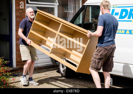 Père Fils aidant à déplacer les meubles d'une chambre d'une commode à une voiture loué dépose van. En Angleterre, Royaume-Uni, Angleterre Banque D'Images