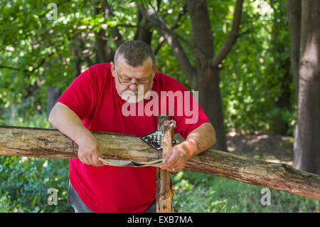 Homme barbu Senior reading newspaper in park Banque D'Images