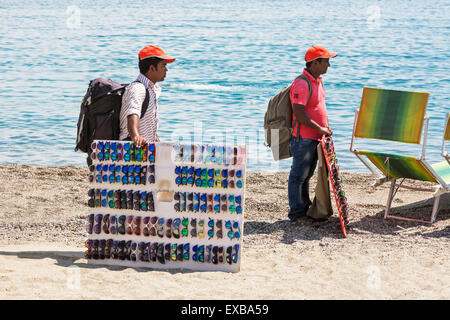 Les hommes de vendre des lunettes de soleil sur la plage de Giardini Naxos, District de Messine, Sicile, Italie Banque D'Images