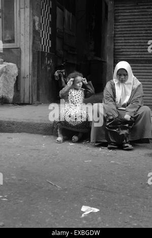 Mère et enfant assis par route, Le Caire, Egypte Banque D'Images