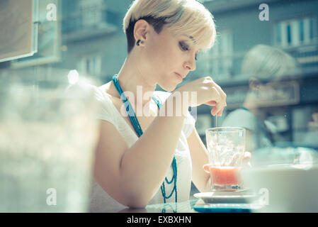 Très belle jeune femme blonde cheveux courts hipster au café Banque D'Images