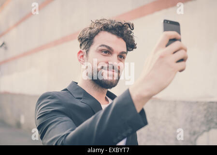 Beau hipster homme moderne à l'aide de smart phone dans la ville selfies Banque D'Images