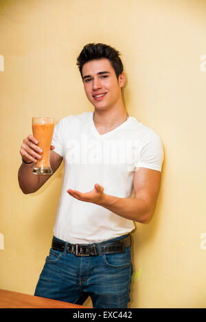 Salut jeune homme avec un smoothie sain fait à partir de fruits tropicaux frais mélangé un toast ou un message d'accueil Banque D'Images