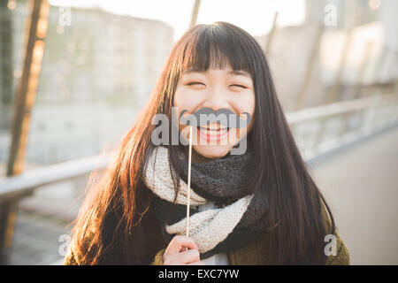 Belle jeune femme asiatique hipster dans la ville - fake moustache drôle avec Banque D'Images