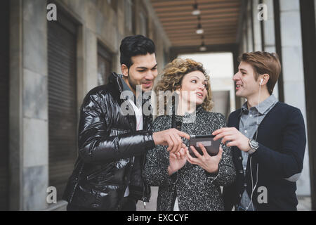 Les gens d'affaires de plein air travail multiraciale en ville connecté avec des dispositifs technologiques Banque D'Images