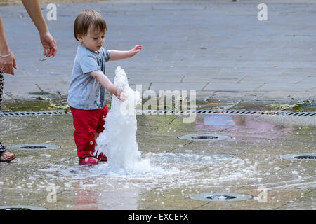 Russell Square Gardens, London, UK. 11 juillet, 2015. Un enfant s'échappe la chaleur à Londres aujourd'hui par rafraîchir dans la fontaine dans Sqauare Russell Gardens. Credit : Gordon 1928/Alamy Live News. Banque D'Images