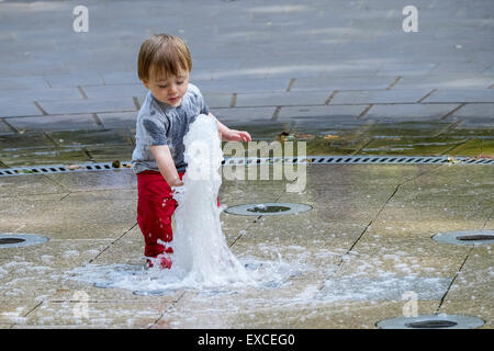 Russell Square Gardens, London, UK. 11 juillet, 2015. Un enfant s'échappe la chaleur à Londres aujourd'hui par rafraîchir dans la fontaine dans Sqauare Russell Gardens. Credit : Gordon 1928/Alamy Live News. Banque D'Images