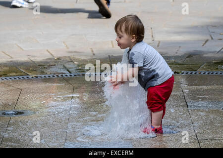 Russell Square Gardens, London, UK. 11 juillet, 2015. Un enfant s'échappe la chaleur à Londres aujourd'hui par rafraîchir dans la fontaine dans Sqauare Russell Gardens. Credit : Gordon 1928/Alamy Live News. Banque D'Images