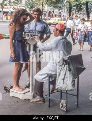 Kiev, Ukraine. 12 Juin, 1989. Une jeune fille est pesé par un vendeur de rue itinérant comme son petit ami regarde au centre-ville de Kiev, la capitale de l'Ukraine. © Arnold Drapkin/ZUMA/Alamy Fil Live News Banque D'Images