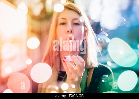 Belle jeune femme blonde sportive hipster en ville blowing bubble Banque D'Images