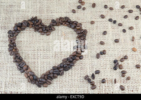 Grains de café en forme de coeur placé sur un sac de café avec des grains de café Banque D'Images