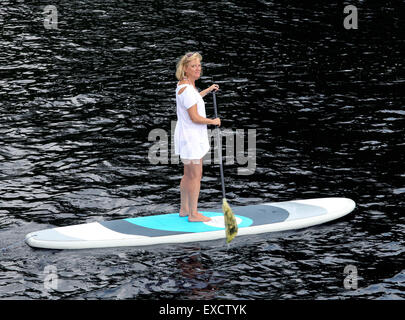 Blonde woman paddling une pagaie sangliers sur le lac Long New York USA US Banque D'Images