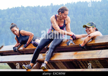 Trois athlètes féminines de la montée d'une rampe en bois sur un enfer. Banque D'Images