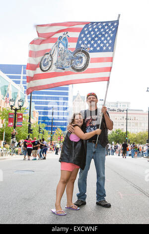 Un père et sa fille, d'un drapeau à la Harley Davidson 110e anniversaire parade à Milwaukee, Wisconsin Banque D'Images