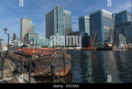 Barge et frégate HMS St Albans à West India Docks en face des bâtiments de Canary Wharf, dans les Docklands de Londres Banque D'Images