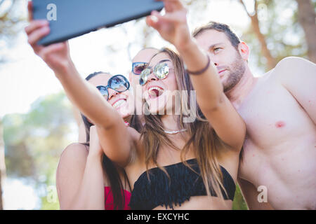 Groupe de jeunes amis multiethnique les femmes et les hommes à la plage en été, rendant selfies Banque D'Images