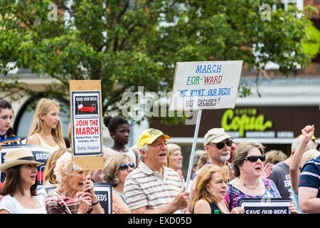 Henley-on-Thames, Royaume-Uni. 11 juillet, 2015. Un homme âgé et une femme, les protestataires à une manifestation, faire des pancartes pour 'Save nos lits' campagne dans une marche de protestation à Henley-on-Thames, Oxfordshire, Angleterre, le samedi 11 juillet 2015 contre la mise en service clinique de l'Oxfordshire plans du groupe de travail pour son nouveau campus de la santé, Hôpital Townlands. Le nouvel hôpital a été initialement prévu pour 18 lits, ont maintenant changé à 5 lits dans une maison de soins d'être construite à côté de l'hôpital, qui laisserait Townlands sans lits pour 6 mois. Credit : Graham Prentice/Alamy Live News Banque D'Images