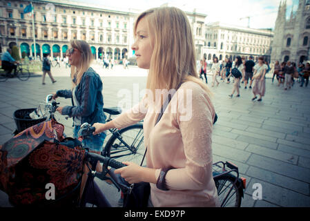 Deux belles femmes blondes shopping sur le vélo dans la ville Banque D'Images