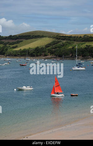 Salcombe, Devon, UK. Petit yacht wit voile rouge, sur l'eau à Salcombe Devon Banque D'Images