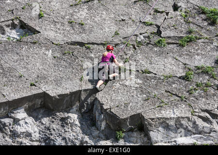 Femme avec des cordes d'escalade sécurisé est une roche verticale le long de la meuse près de Dinant, Belgique Banque D'Images