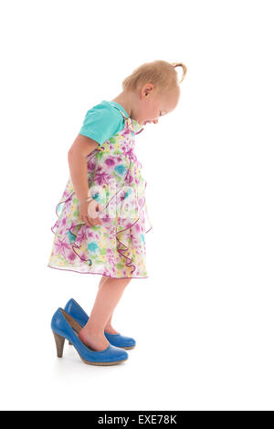 Bébé fille inmothers permanent big shoes isolated over white background Banque D'Images