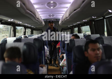 L'État de Michoacan, au Mexique. 12 juillet, 2015. Un membre de la Police fédérale vérifie à l'intérieur d'un bus de passagers dans les environs de le péage de l'autoroute de l'Ouest Contepec à Michoacan, Mexique, le 12 juillet 2015. Cartel de la drogue mexicain Joaquin El Chapo 'Pivot' Guzman s'est échappé de prison grâce à un tunnel de 1,5 km dans sa cellule, a déclaré dimanche que les autorités.Guzman, chef du cartel de la drogue de Sinaloa, a disparu de la prison de l'Altiplano à sécurité maximale à l'extérieur de la ville de Mexico samedi soir, selon la Commission nationale de sécurité. Credit : Armando Solis/Xinhua/Alamy Live News Banque D'Images