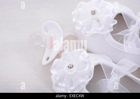 Fond blanc neutre de douche de bébé avec des chaussons pour bébé, perles, et le sucre les amandes sur table en bois rustique chic minable, avec l'exemplaire sp Banque D'Images