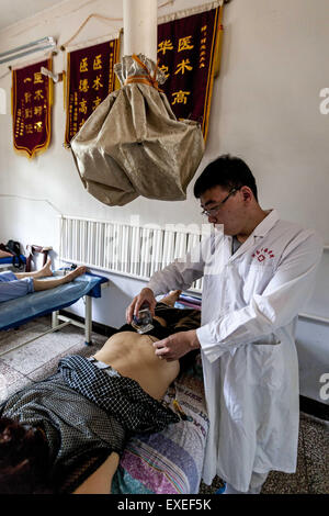 Hua County, Henan, CHN. 11 juillet, 2015. Hua County, CHINE - 11 juillet 2015 : (usage éditorial uniquement. Chine OUT) Un homme est en train de faire saigner la thérapie. Comme le chien jours viennent en Chine, les gens s'entassant dans les hôpitaux MTC pour prévenir ou réduire la gravité des maux de l'hiver. ''Traitement des maladies de l'hiver à l'été'' est une tradition ancienne. C'est l'heure de rituel annuel de la médecine traditionnelle chinoise - obtenir des packs, des décoctions et l'acupuncture en été pour rester en bonne santé en hiver. © SIPA Asie/ZUMA/Alamy Fil Live News Banque D'Images