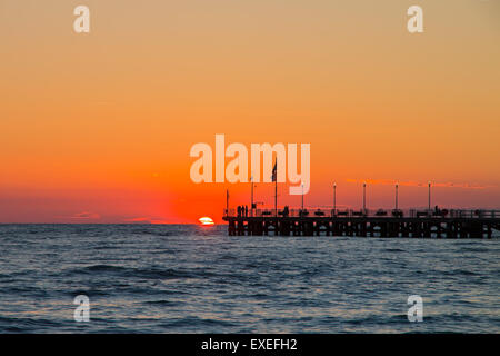 Forte dei Marmi's pier au coucher du soleil, les gens regardant le soleil dans un beau jour. orange ciel Banque D'Images