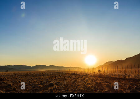 Farmland with fence au coucher du soleil, ferme Tiras Tiras, montagnes, la Namibie Banque D'Images