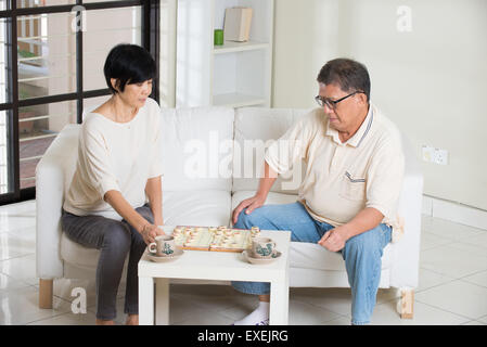 Asian senior couple jouant aux échecs à la maison Banque D'Images