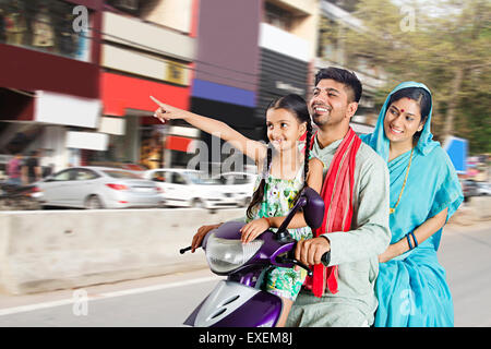 Les parents ruraux indiens avec fille Route Autoroute Équitation Scooty pointer du doigt Banque D'Images