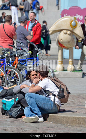 Londres, Angleterre, Royaume-Uni. Trafalgar Square : des gens assis sur le sol / modèle Shaun le mouton de Nelson (2015) Banque D'Images