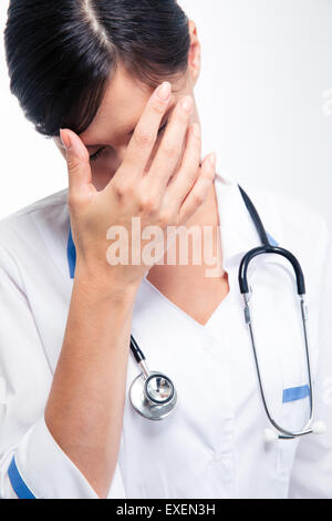 Souligné médecin femme avec stéthoscope et looking at camera isolé sur fond blanc Banque D'Images