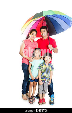 Les parents indiens avec les enfants la protection pluie parapluie Banque D'Images