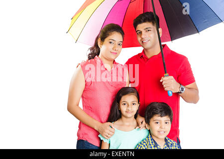 Les parents indiens avec les enfants la protection pluie parapluie Banque D'Images