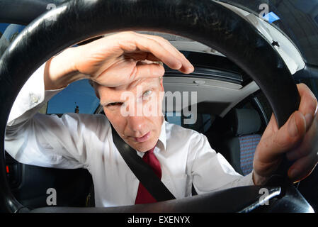 Fatigué businessman driving car Banque D'Images